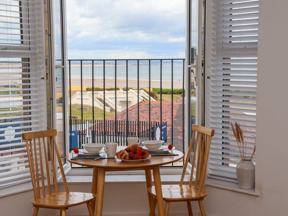 A dining table with two chairs and a view of the sea at Apartment 4 ( 1 bed ) Redcar