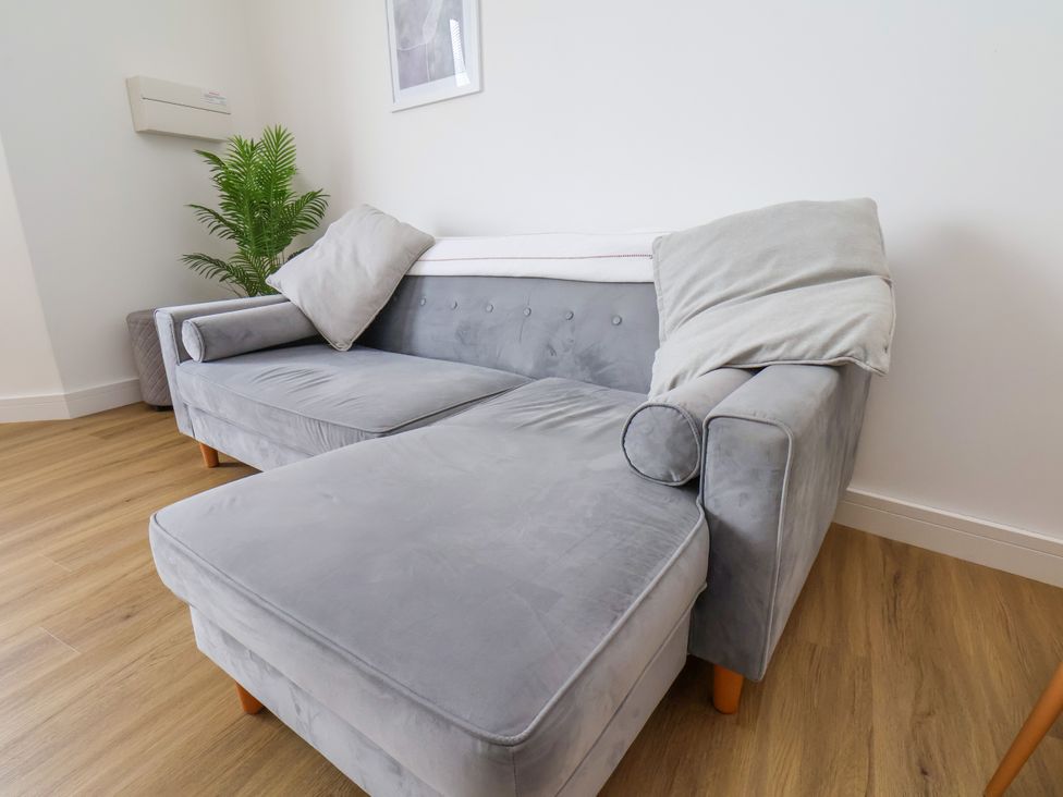 A sofa with cushions and a plant at Apartment 4 (1 bed) Redcar