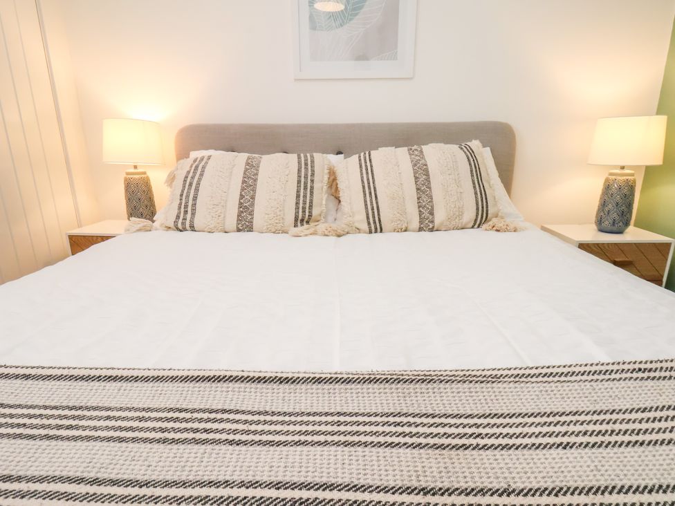A bed with pillows and lamps in a bedroom at Apartment 4 ( 1 bed ) in Redcar