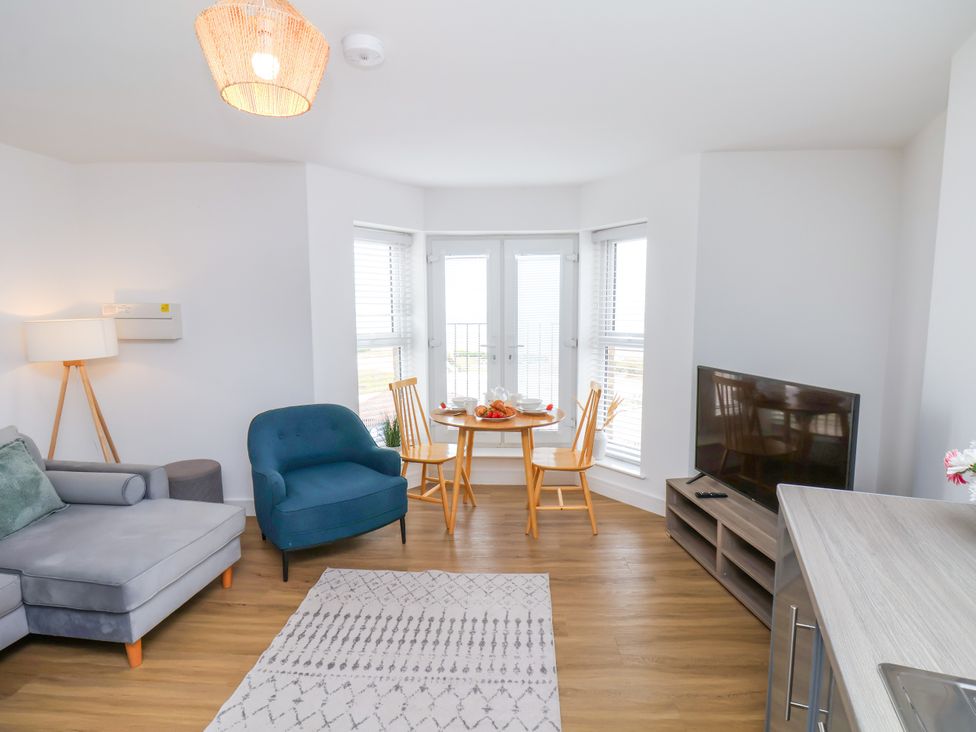 A living room with a sofa, dining table and television at Apartment 5 ( 1 bed ) in Redcar