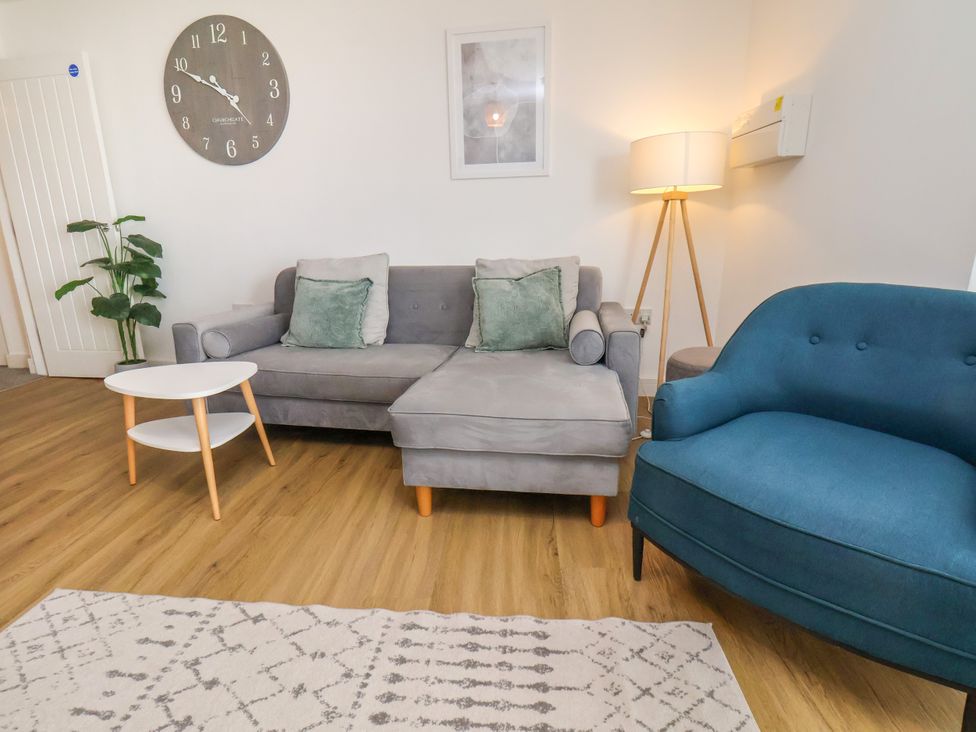 A living room with a sofa and blue chair at Apartment 5 (1 bed) Redcar