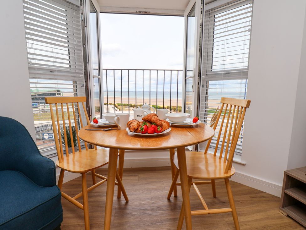 A dining table with chairs and breakfast items at Apartment 5 (1 bed) Redcar
