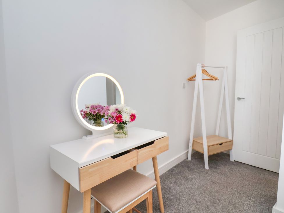 A bedroom with a vanity table and flowers at Apartment 5 ( 1 bed ) in Redcar