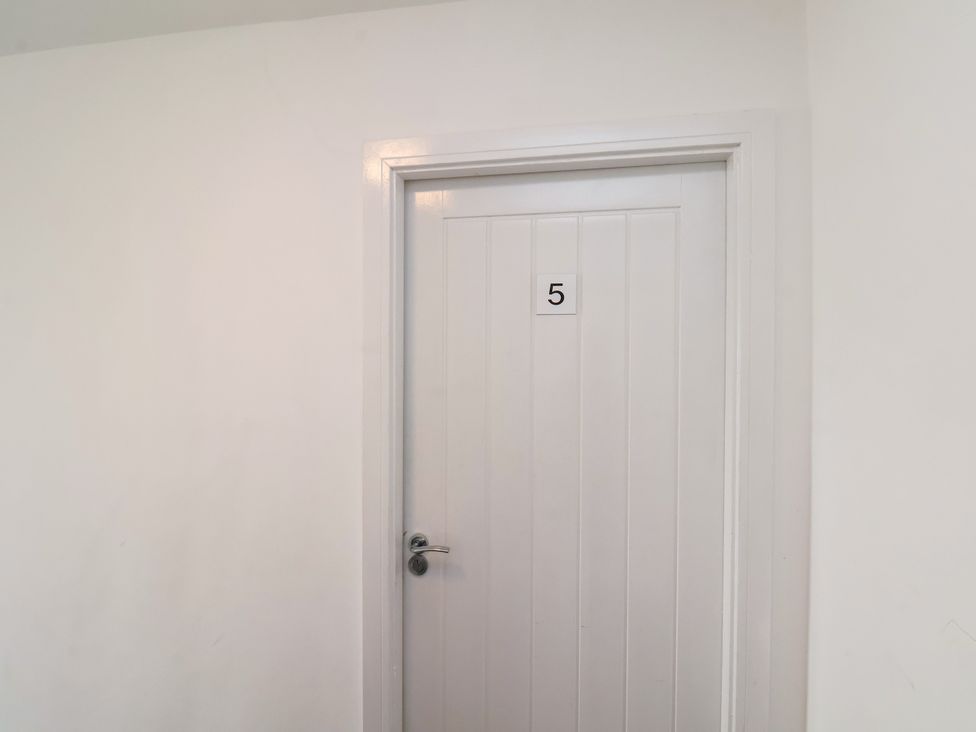 A door with the number 5 in a hallway at Apartment 5 ( 1 bed ) Redcar