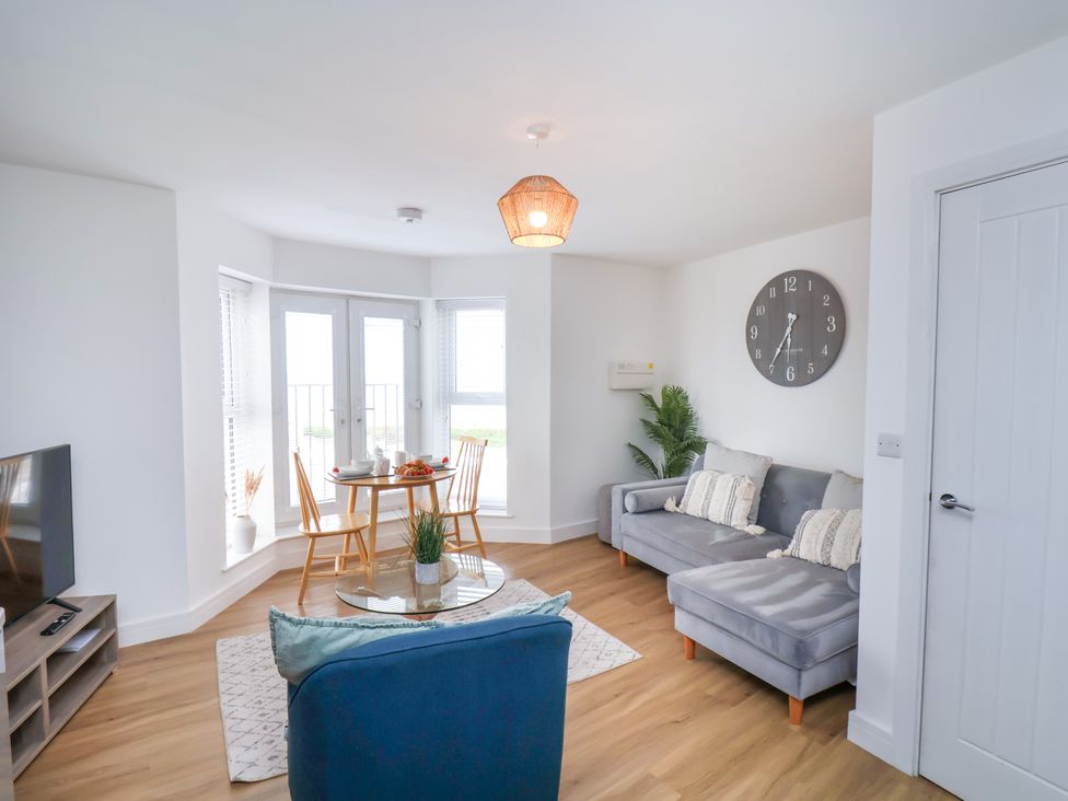 A living room with a sofa and dining table at Apartment 6 (1 bed) Redcar