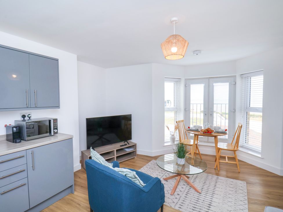 A living room with a microwave and television at Apartment 6 ( 1 bed ) Redcar