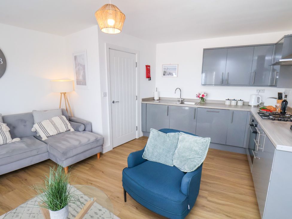 A living room with a sofa and kitchen units at Apartment 6 (1 bed) Redcar