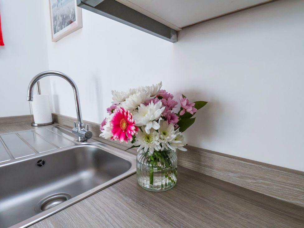A kitchen with a sink and a floral arrangement at Apartment 6 ( 1 bed ) in Redcar