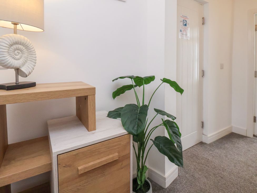 A hallway with a lamp, side table and indoor plant at Apartment 6 ( 1 bed ) Redcar