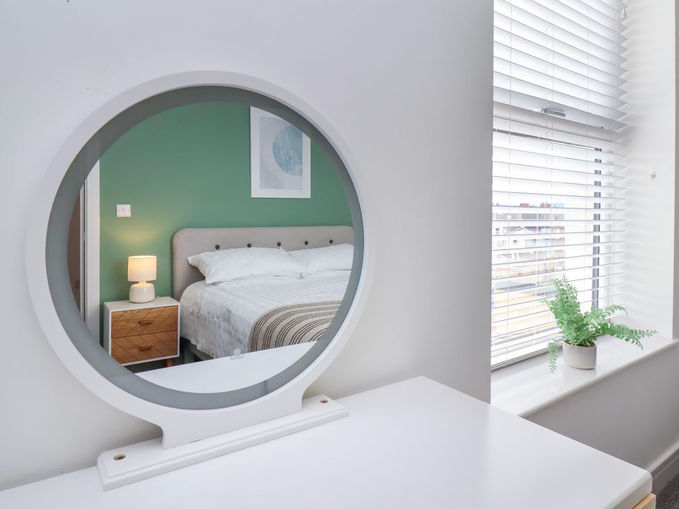 A bedroom with a bed and a mirror at Apartment 6 (1 bed) Redcar