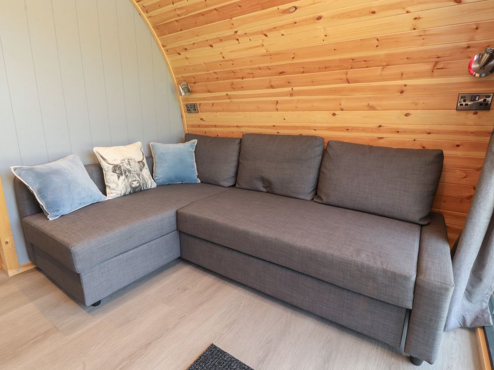 A living room with a gray sofa and cushions at Barley near Nelson