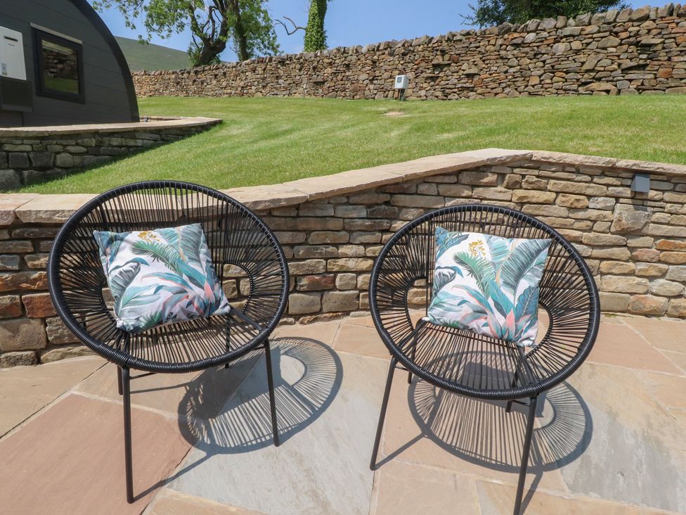Two black chairs with decorative pillows on a patio at Black Moss Nelson