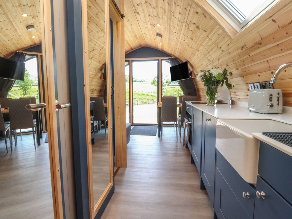 A kitchen with a sink and dining table at Black Moss in Nelson