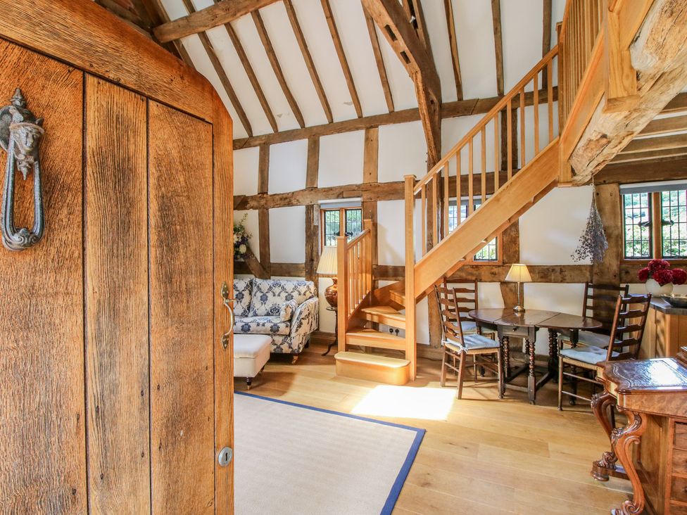 A living room with a staircase and seating area at Courtyard Cottage Little Stretton