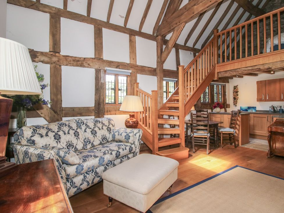 A living room with a sofa and stairs at Courtyard Cottage in Little Stretton