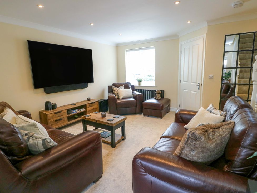 A living room with leather sofas and a TV at 20 Cysgod Y Bryn in Rhos-On-Sea