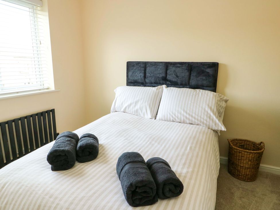A bedroom with a bed and towels at 20 Cysgod Y Bryn Rhos-On-Sea