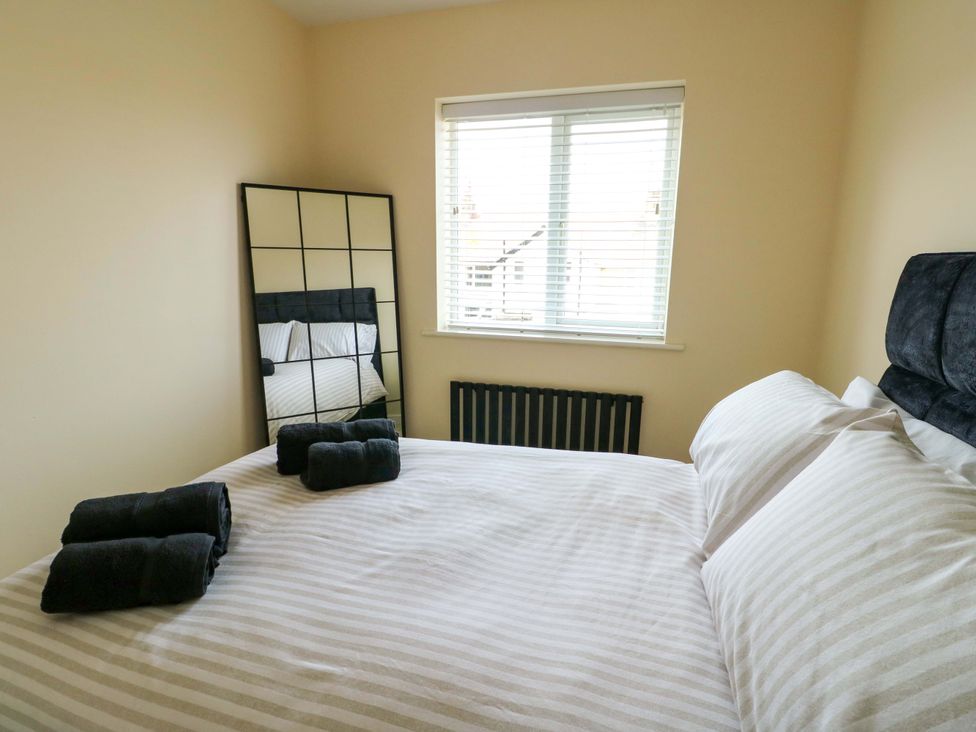 A bedroom with a bed and a mirror at 20 Cysgod Y Bryn Rhos-On-Sea