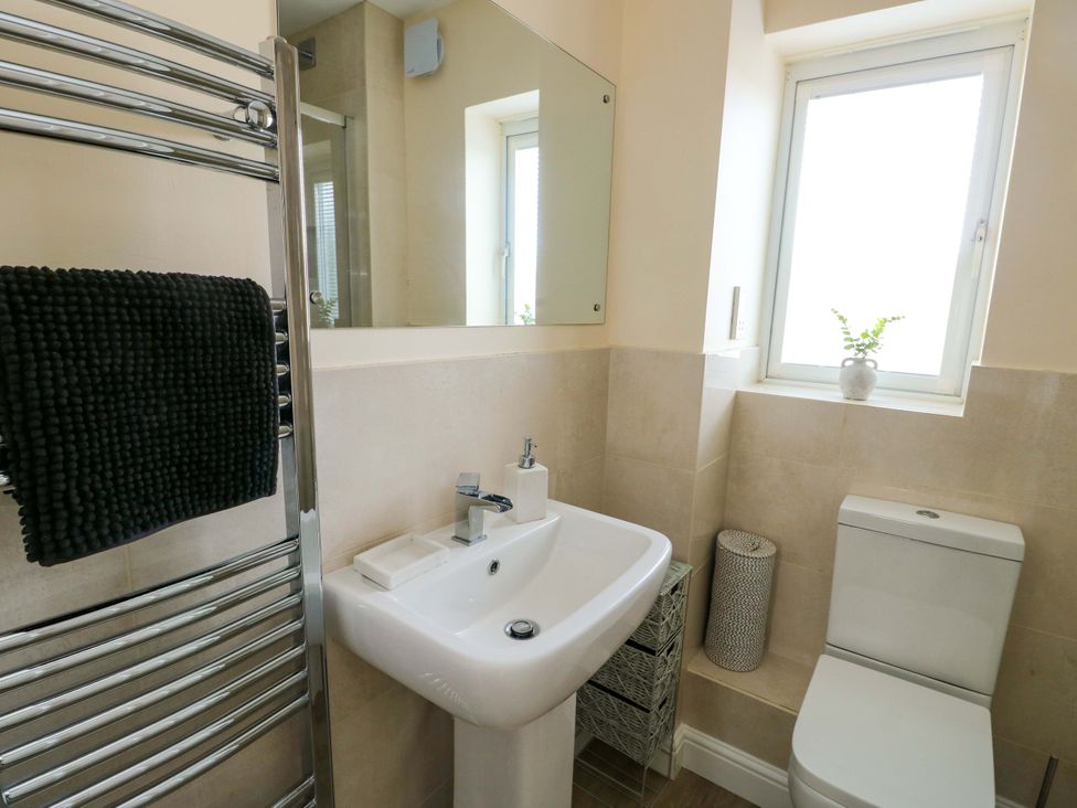 A bathroom with a sink, toilet, and towel radiator at 20 Cysgod Y Bryn Rhos-On-Sea