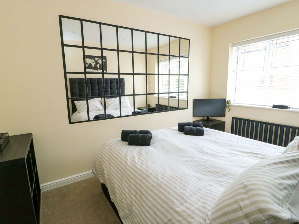 A bedroom with a bed and a mirror at 20 Cysgod Y Bryn Rhos-On-Sea