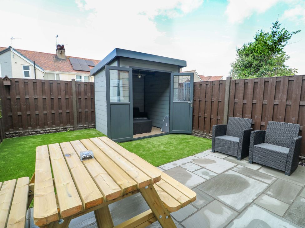 A garden with a shed, table, and chairs at 20 Cysgod Y Bryn Rhos-On-Sea