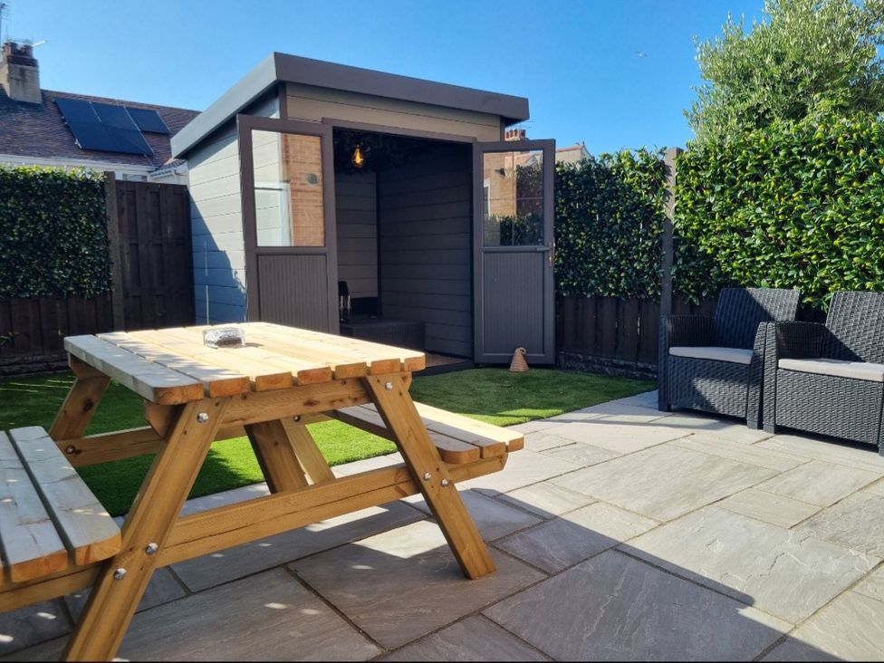 A garden with a shed and seating area at Hafan Rhos in Rhos-On-Sea