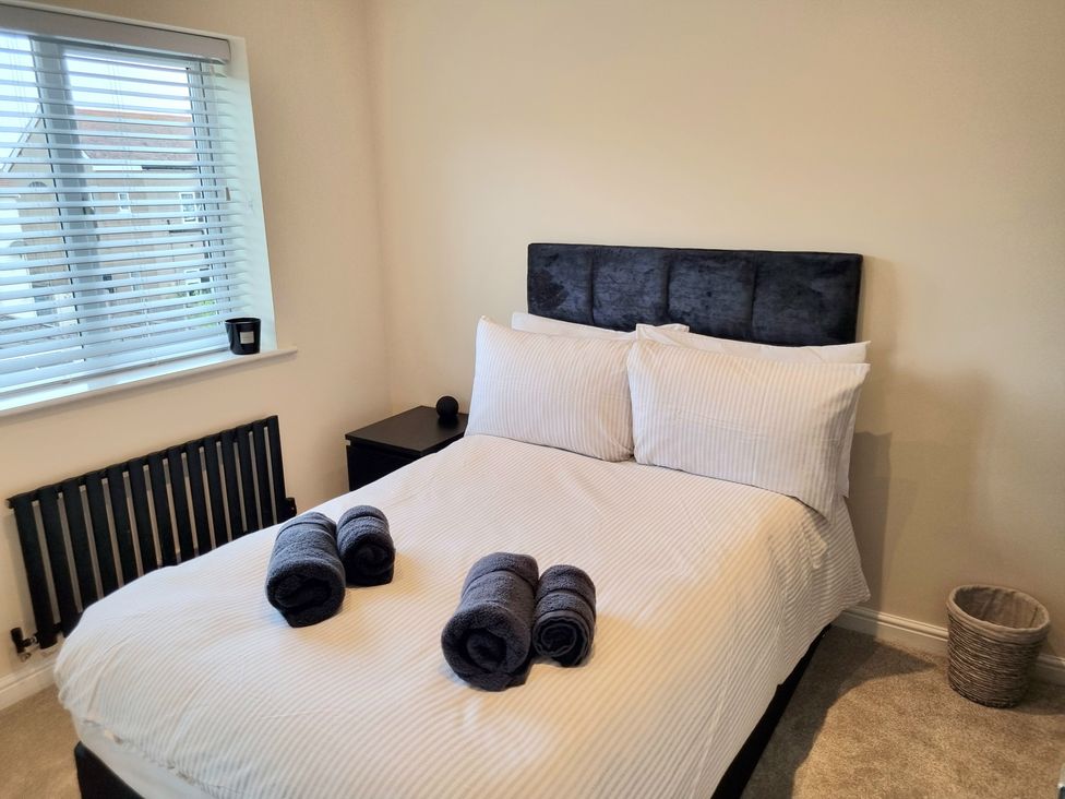 A bedroom with a bed and towels arranged at Hafan Rhos in Rhos-On-Sea