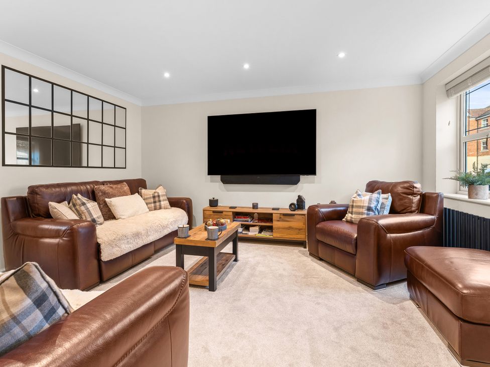 A living room with leather sofas and a television at Hafan Rhos in Rhos-On-Sea