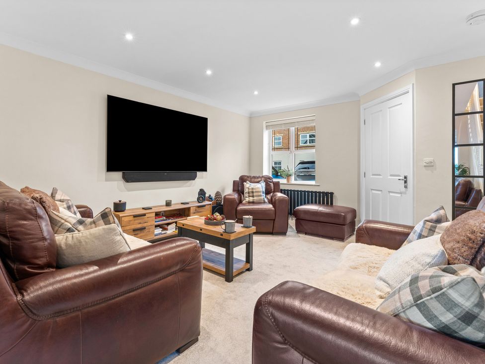 A living room with leather sofas and a television at Hafan Rhos Rhos-On-Sea