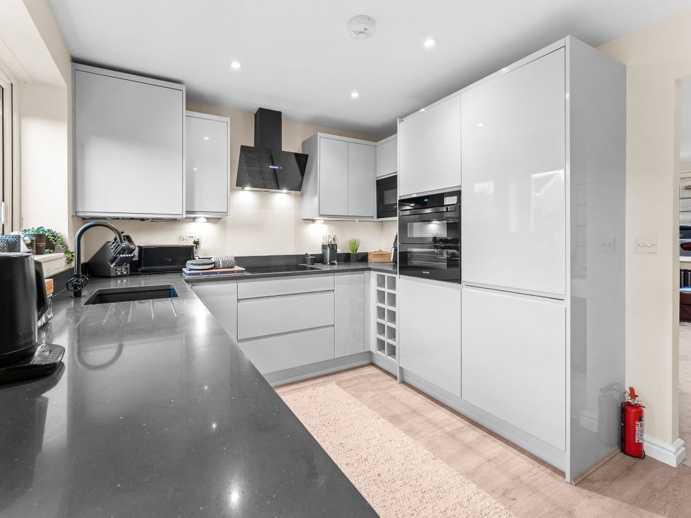 A kitchen with modern appliances and cabinets at Hafan Rhos in Rhos-On-Sea