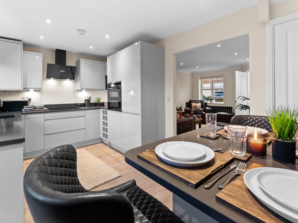 A kitchen with a dining area featuring a table and chairs at Hafan Rhos in Rhos-On-Sea