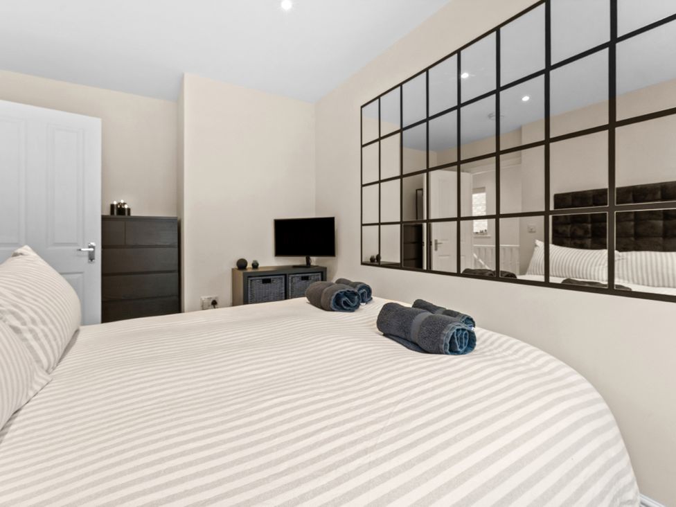 A bedroom with a bed and towels on top at Hafan Rhos in Rhos-On-Sea