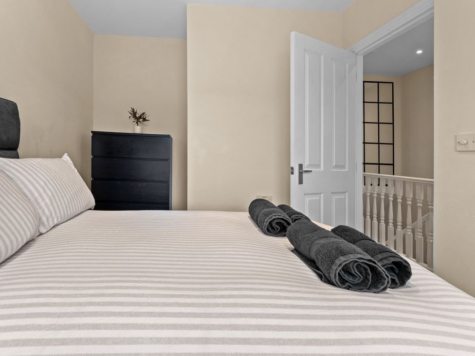 A bedroom with a bed and towels on it at Hafan Rhos in Rhos-On-Sea