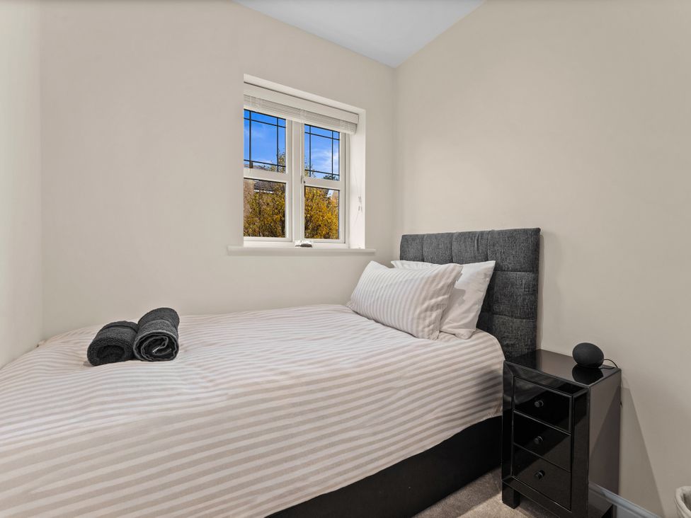A bedroom with a bed and a window at Hafan Rhos in Rhos-On-Sea