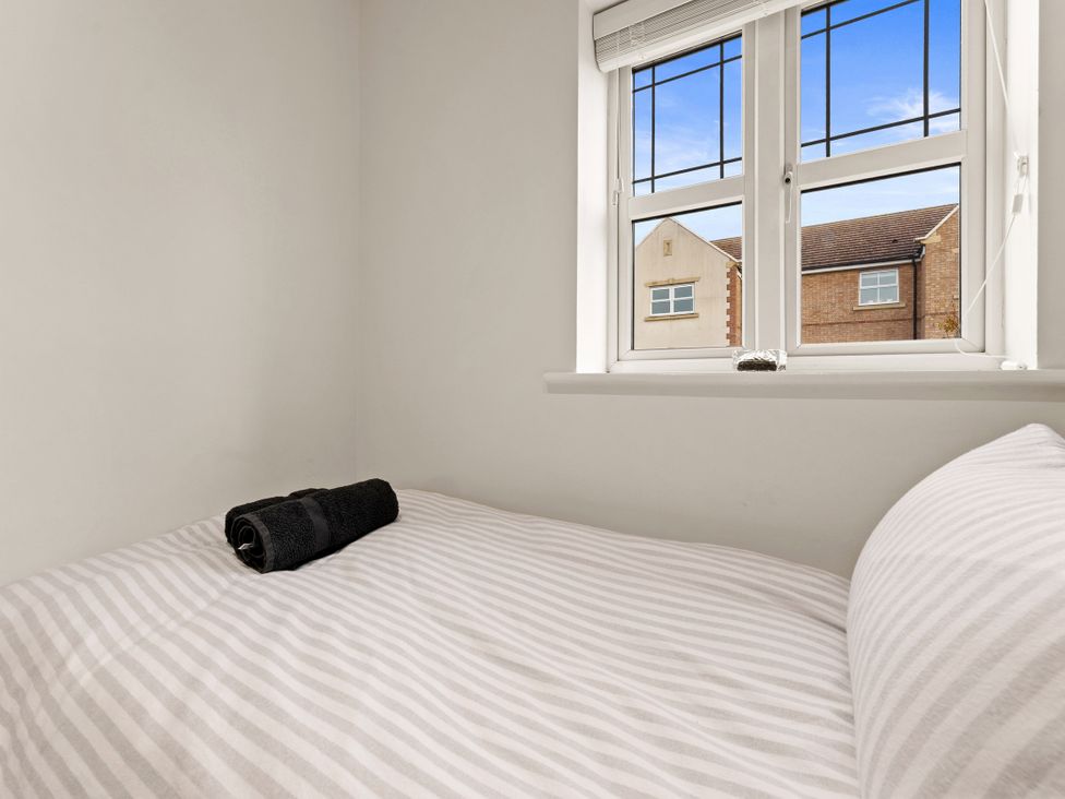 A bedroom with a bed and a towel at Hafan Rhos in Rhos-On-Sea