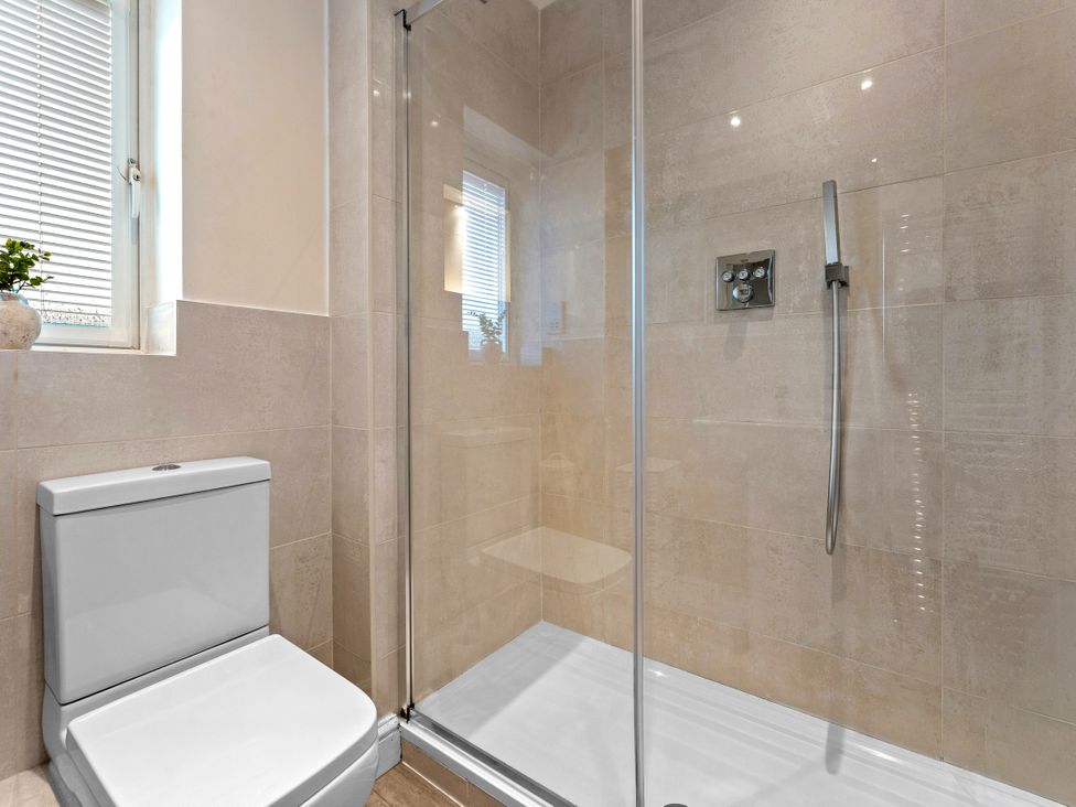 A bathroom with a shower and toilet at Hafan Rhos in Rhos-On-Sea