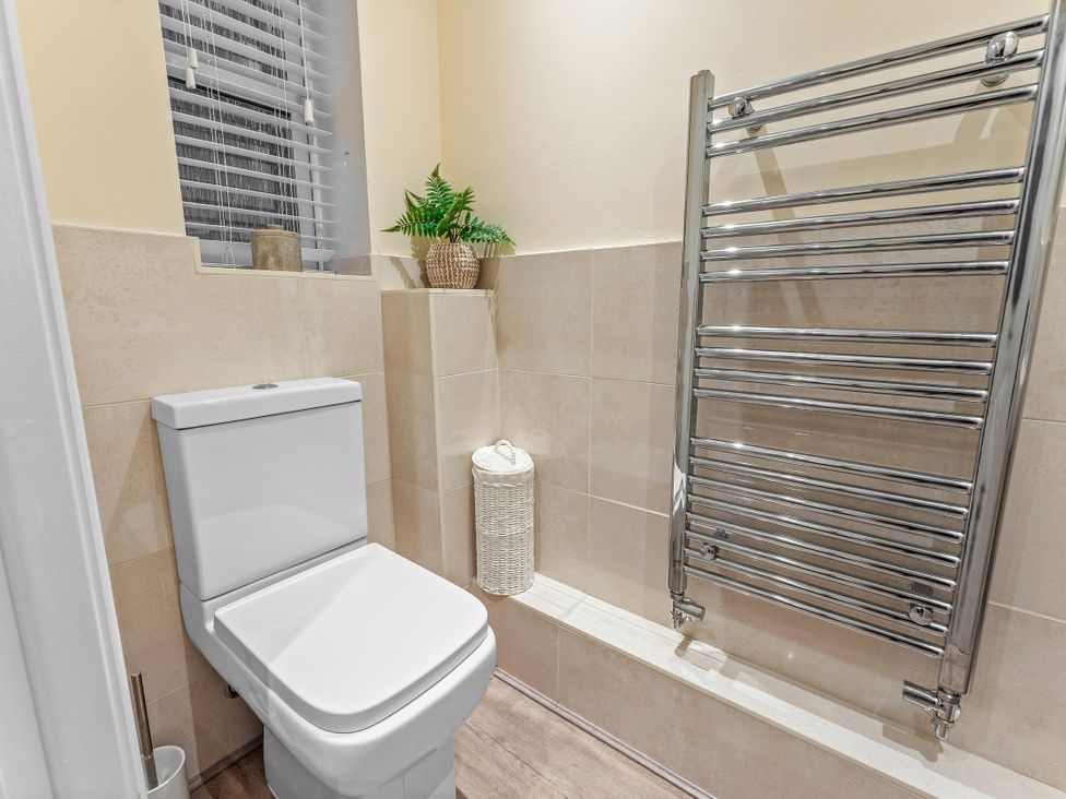 A bathroom with a toilet and a towel rack at Hafan Rhos in Rhos-On-Sea