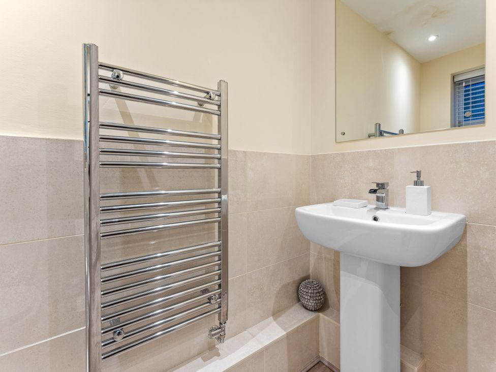 A bathroom featuring a towel radiator and a sink at Hafan Rhos in Rhos-On-Sea