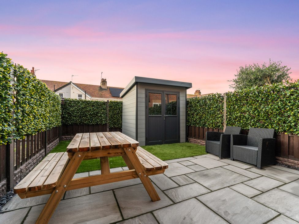 A garden with a shed and seating area at Hafan Rhos in Rhos-On-Sea