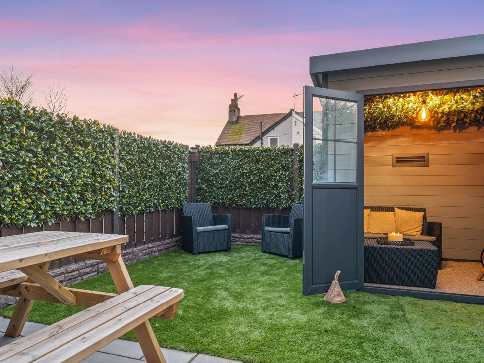 A garden with a seating area and shed at Hafan Rhos in Rhos-On-Sea