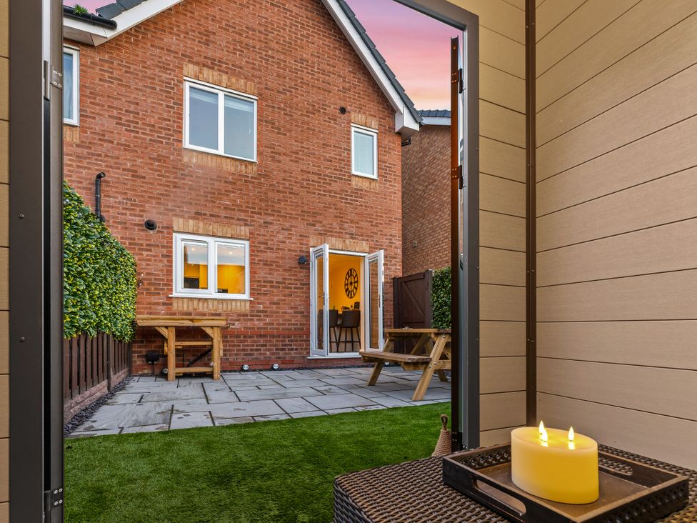 A garden view featuring a table and bench at Hafan Rhos in Rhos-On-Sea
