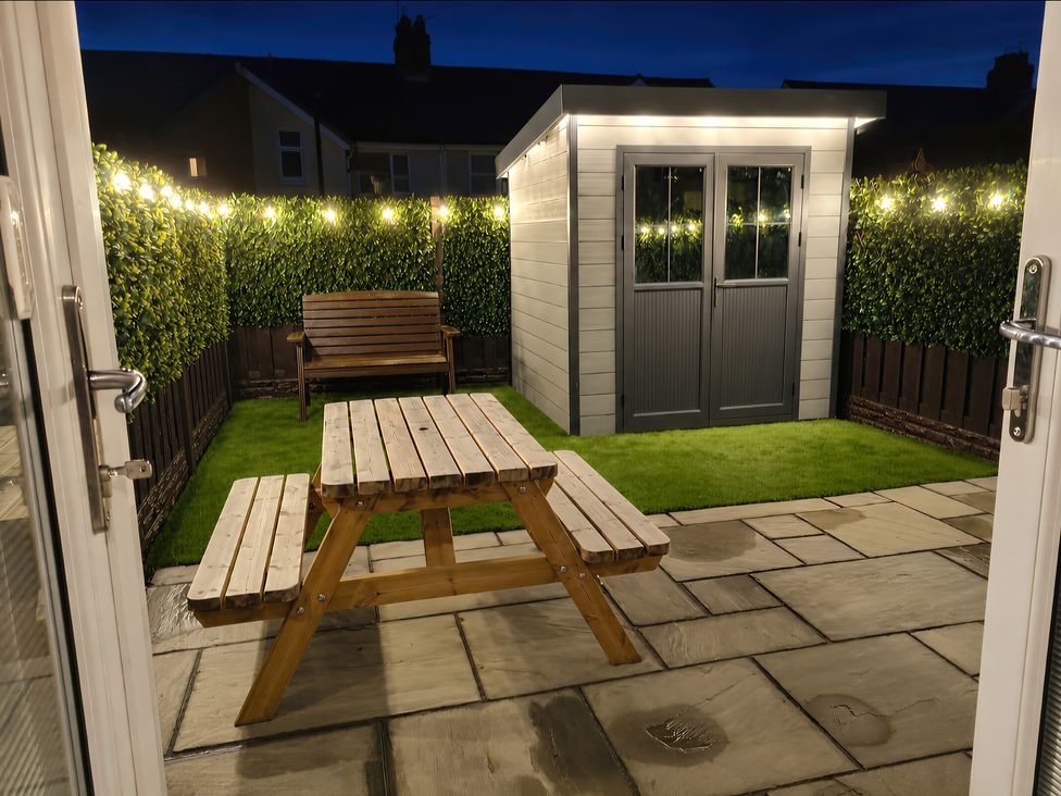A garden with a shed and a picnic table at Hafan Rhos in Rhos-On-Sea