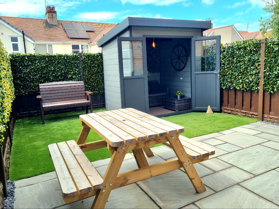 A garden with a table and shelter at Hafan Rhos in Rhos-On-Sea