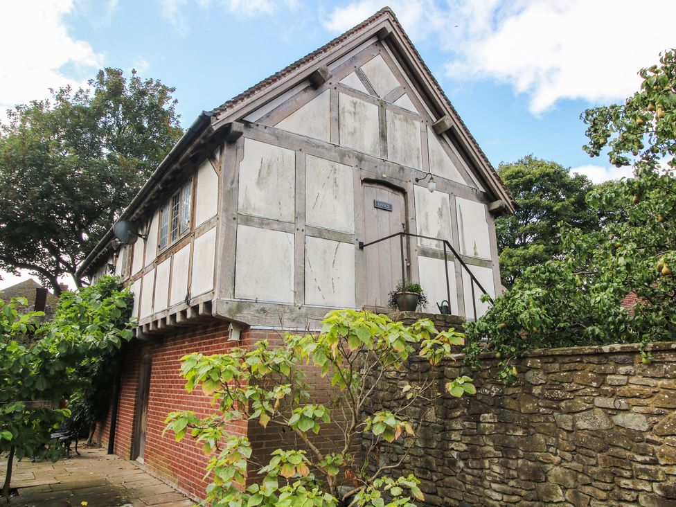 A house with a door and windows in a garden at The Coach House in Little Stretton