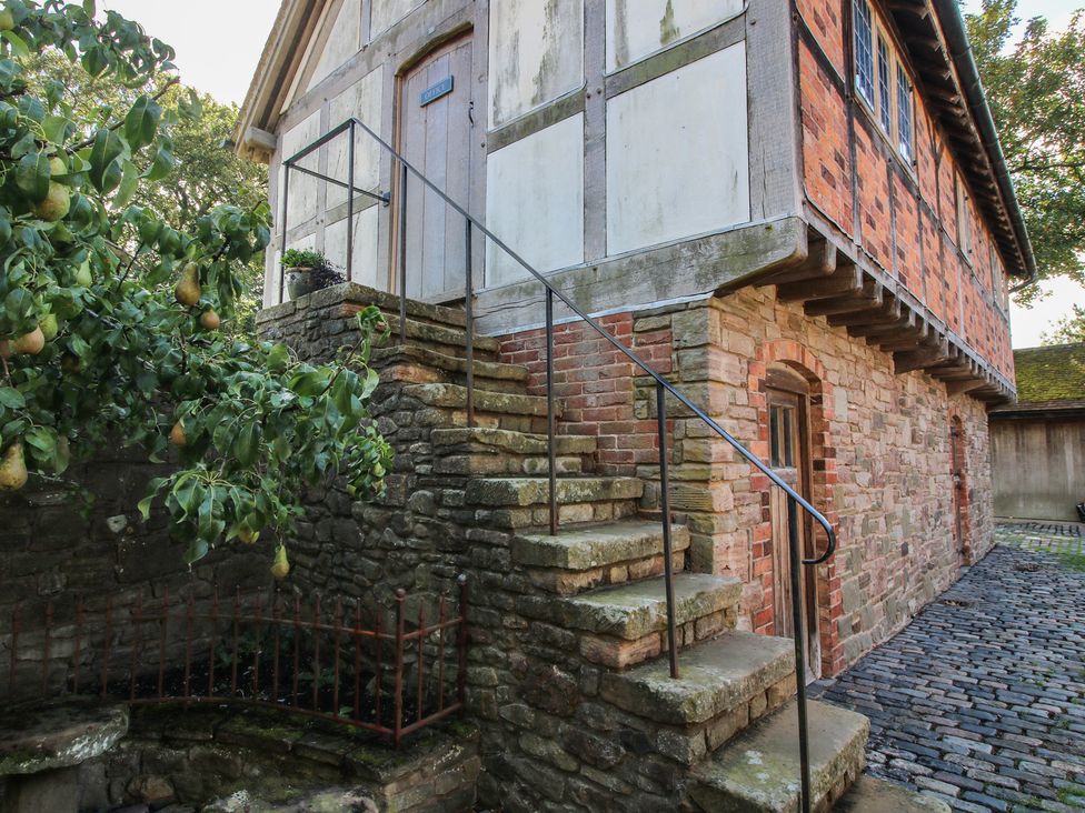 An outdoor area with stairs leading to a door at The Coach House in Little Stretton