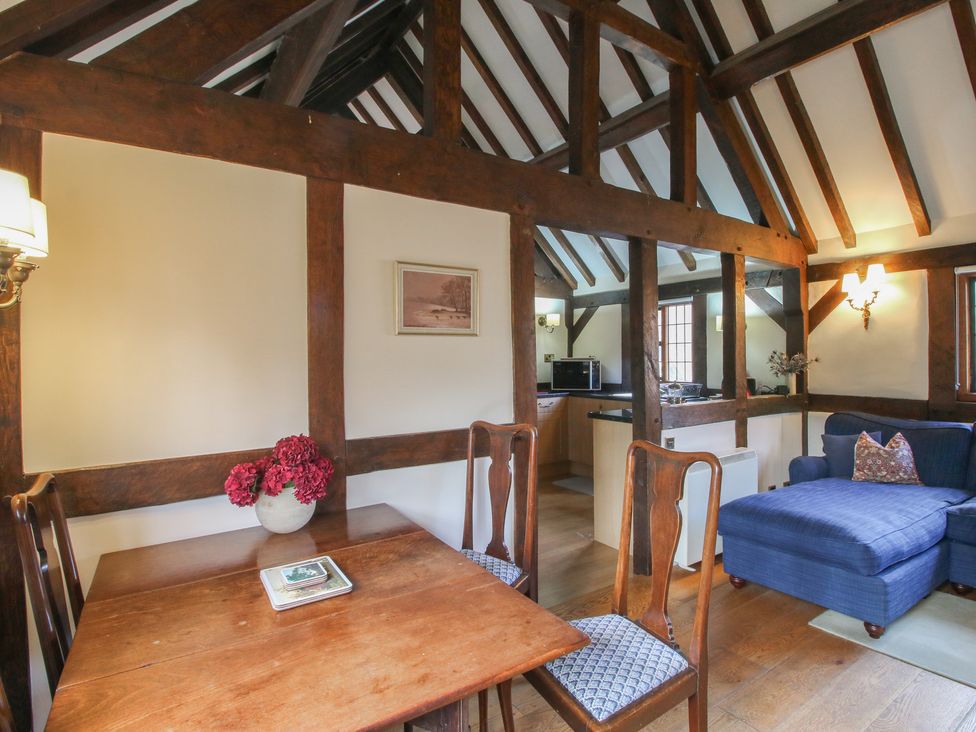 A living room with a dining area and kitchen at The Coach House in Little Stretton