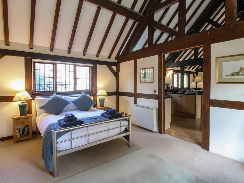 A bedroom with a bed and nightstand at The Coach House Little Stretton