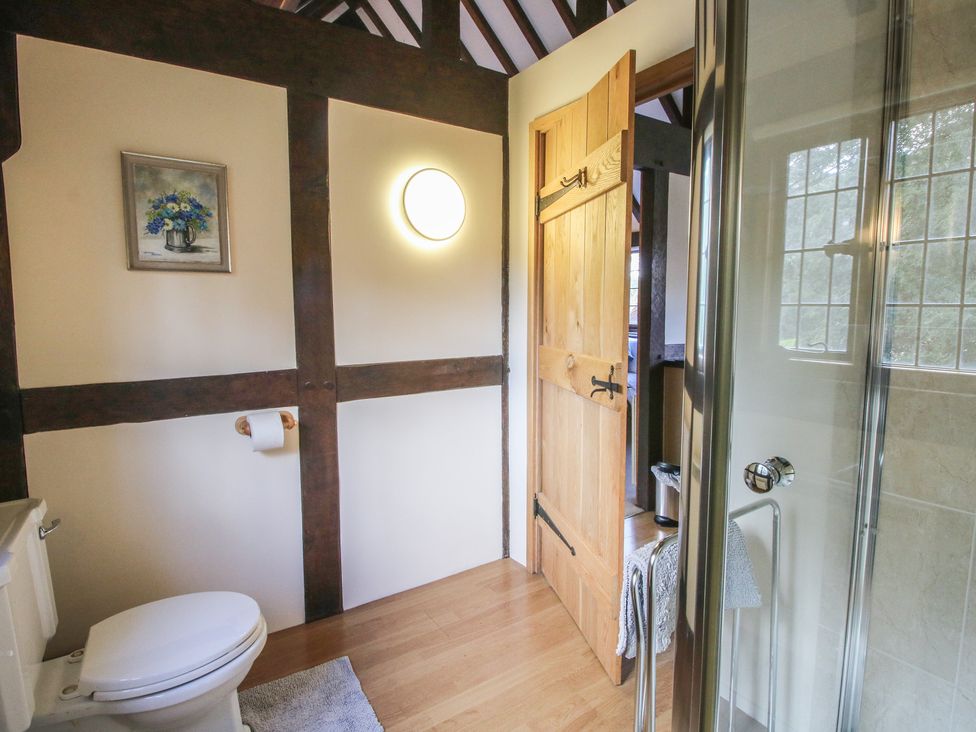 A bathroom with a toilet and shower at The Coach House in Little Stretton