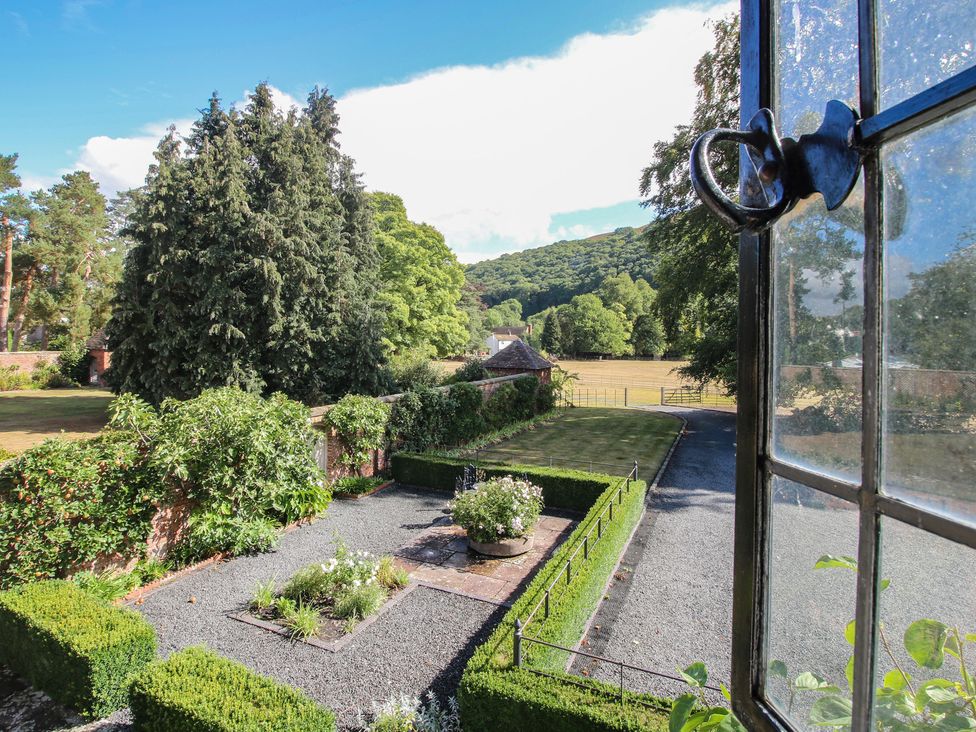 View of a garden with hedges and trees at The Coach House Little Stretton