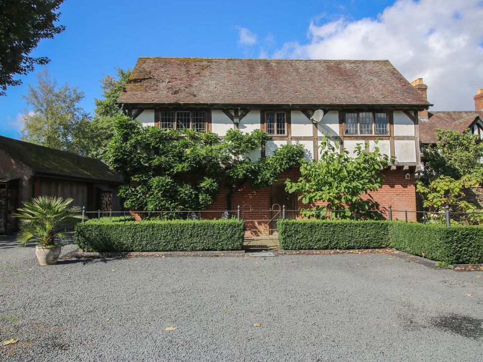 A front view of a building with surrounding greenery at The Coach House in Little Stretton